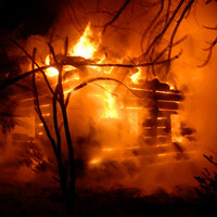 Immagine di una capanna in preda alle fiamme.